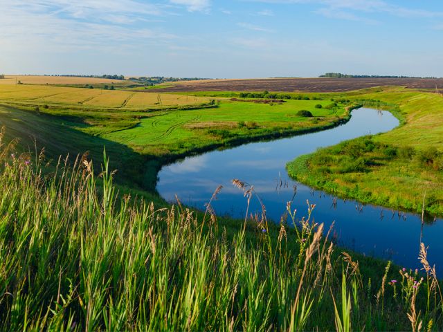 Photo of a farm near a river